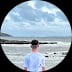 View through binocular lens of a small boat on calm water with blue sky and clouds
